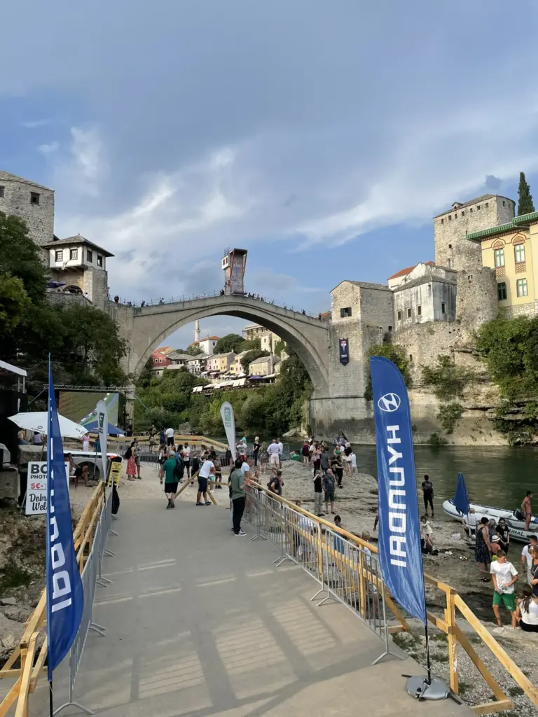 Le pont Stari Most de Mostar enjambant la rivière Neretva, entouré de bâtiments historiques, sous un ciel clair.