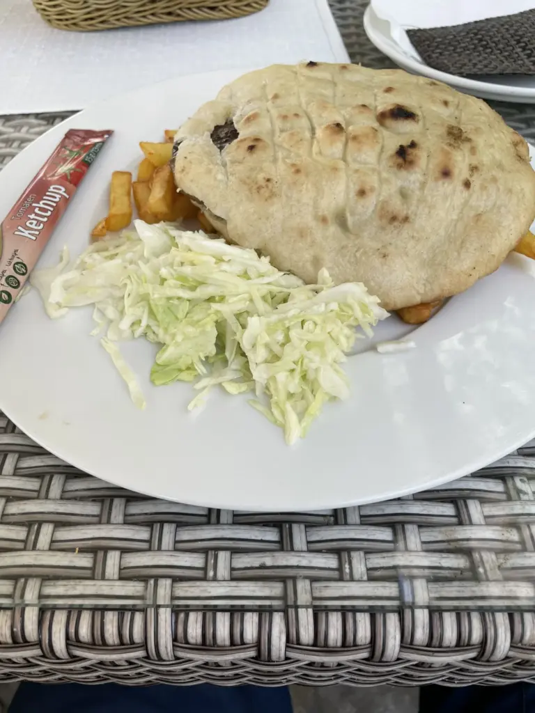 Assiette de ćevapi servis dans un restaurant à Blagaj, accompagnés de pain pita et d’oignons.
