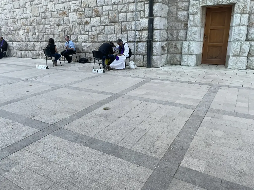 Fidèles participant à des confessions en plein air devant l’église.
