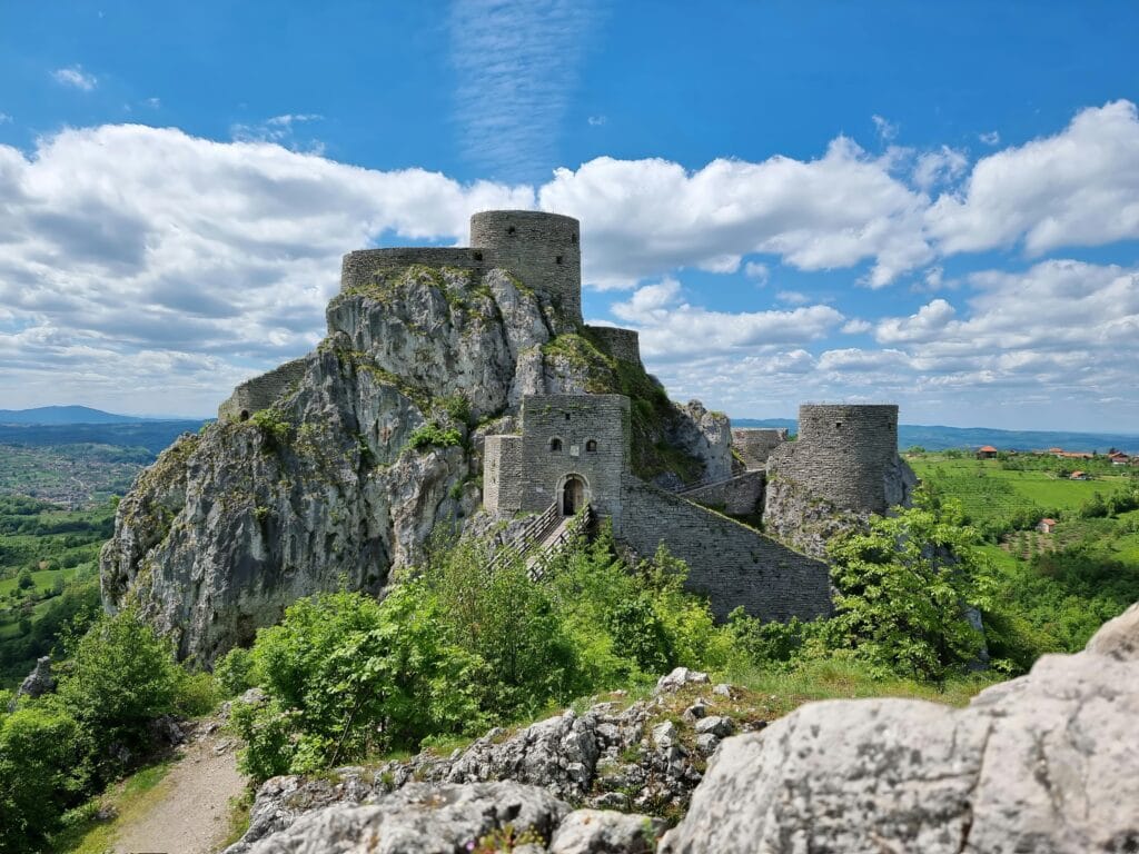 Vue de la forteresse historique de Srebrenik en Bosnie-Herzégovine, sur un éperon rocheux, éclairée par le soleil.