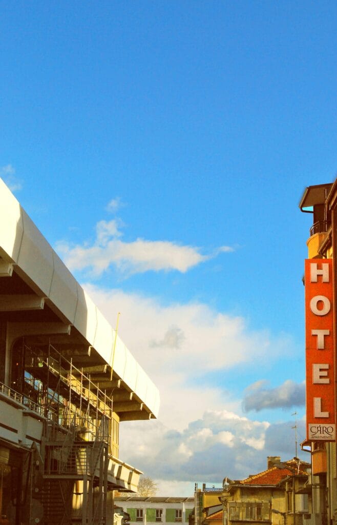 Vue urbaine avec une pancarte d’hôtel sur le côté de la rue, entourée de bâtiments